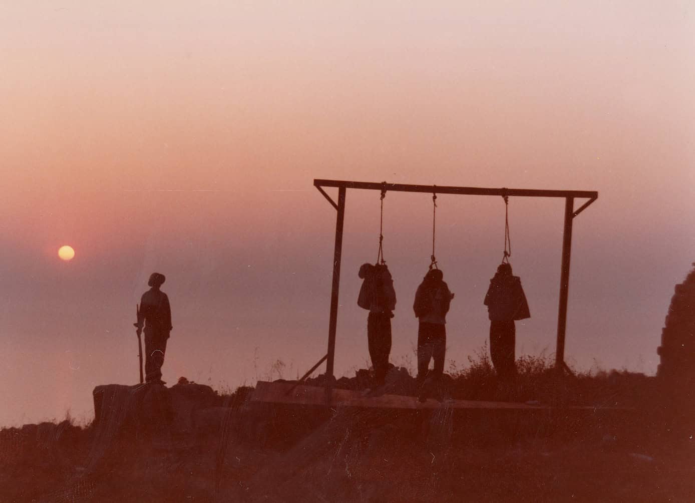 Silhouette of a person watching three swings at sunset, symbolizing resilience.